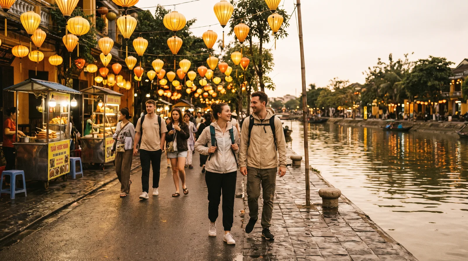 Lantern-lit streets of Hoi An old town at dusk with travellers walking along the riverside